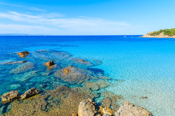 Rocks in crystal clear azure sea water in Grande Sperone bay, Corsica island, France