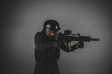 sniper, airsoft player with gun, helmet and bulletproof vest on