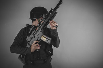 sport airsoft player with gun, helmet and bulletproof vest on gr