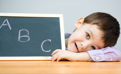 Cute boy is holding blackboard