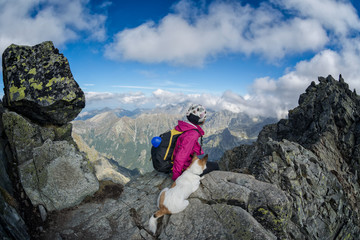 female hiker and her dog on a rocky mountain top