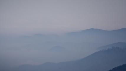 hills sticking out of thick fog