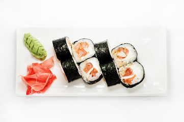 Sushi with salmon wrapped in nori on a white plate