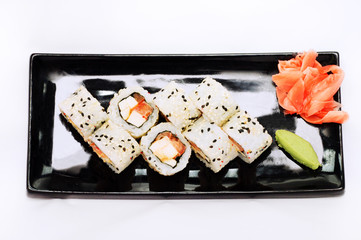 sushi roll platted on a black plate.