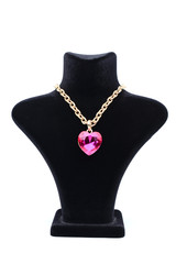 Pendant with pink heart on a mannequin isolated on white