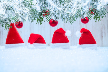 Red Santa hat in the snow, Fir tree with baubles