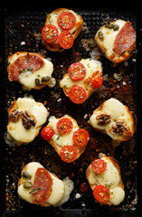 Crostini with various toppings on a dark background