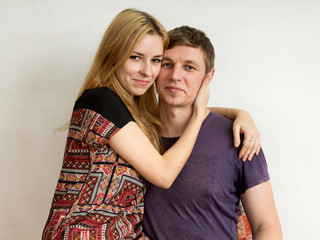 A couple - a  blond woman in a bright dress and a man in purple