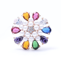 round brooch with colored stones isolated on white