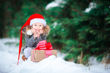 Adorable little girl with christmas box gift in winter outdoors
