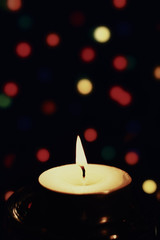 Candles against the backdrop of colored lights