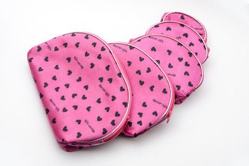 many pink cosmetic bags isolated on white