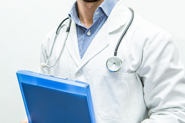 uomo dottore con stetoscopio, cartellina medica e camice per visita in studio in ospedale