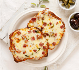 Warm toast with cheese and chopped salami on the white board