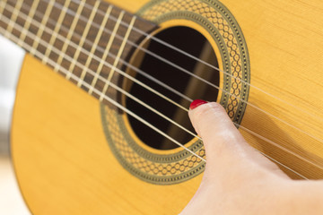 Hand playing acoustic guitar..