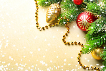 Christmas fir tree branches with toys and beads on paper background