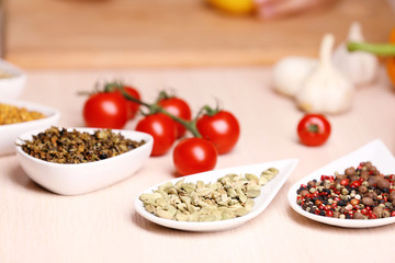 Variety of spices in ceramic containers on the kitchen table