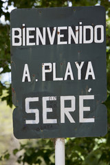 Rusted welcome to beach of Ser&eacute; sign written in Spanish