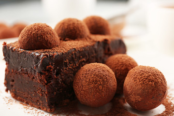 Slice of chocolate cake with a truffle on plate closeup