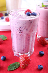 Milkshakes with berries at red textile on light background