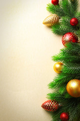 Christmas fir tree branches with toys on paper background