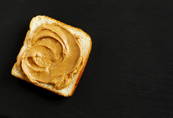 Peanut butter sandwich on black backgrpund with copy space
