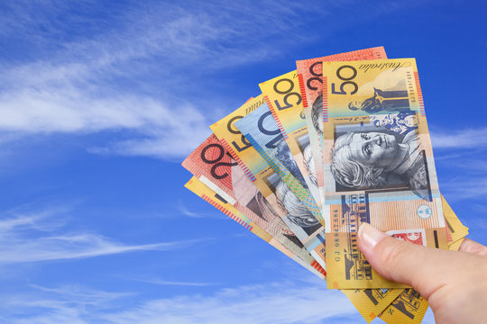 Handful of Australian Money over Blue Sky.