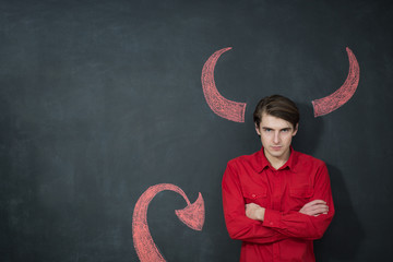 Serious businessman representing the demon on grey background