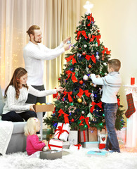 Obraz na płótnie Canvas Family decorating Christmas tree in home holiday living room