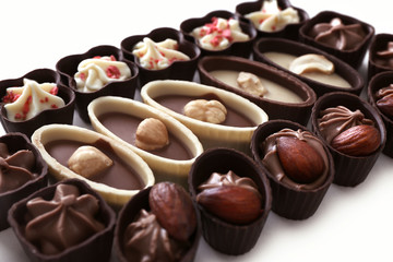 Composition of chocolate candies on white background, close up