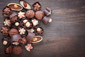 Delicious chocolate candies on wooden background, close up