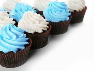 Fresh delicious cupcakes in a row isolated on white background