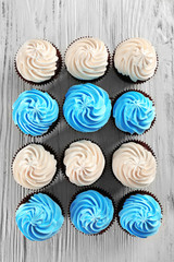 Tasty colourful cupcakes in a row on white wooden  background