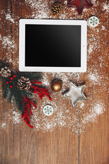 Tablet and Christmas decor on wooden background