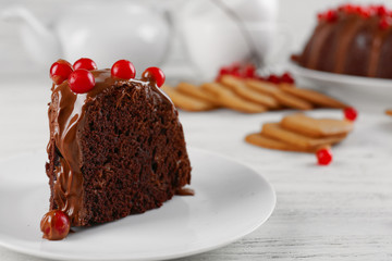 Piece of chocolate cake with snowball tree berries on a table
