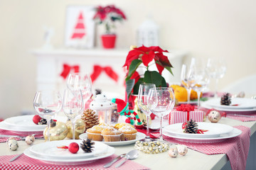 Christmas table setting with holiday decorations on fireplace background