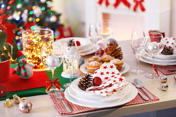 Christmas table setting with holiday decorations on fireplace background