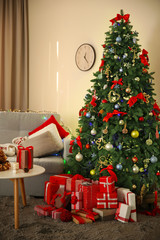 Christmas fir tree with gifts in living room