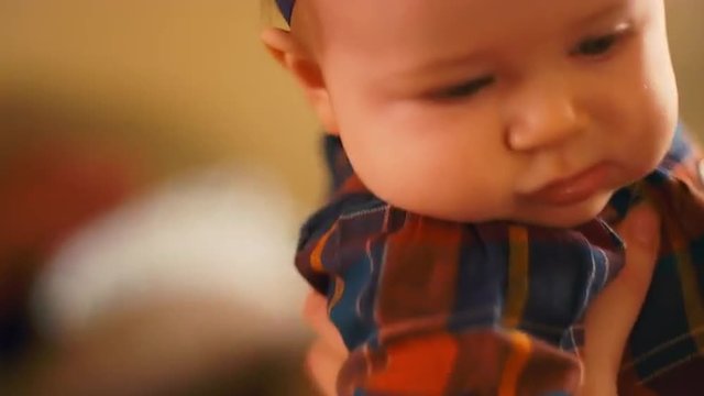 Close up of a baby sitting on her mother's lap at home, going in and out of focus