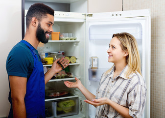 housewife and handyman near fridge