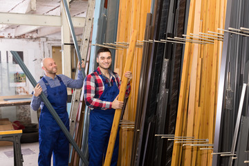 Two workers choosing PVC window profile