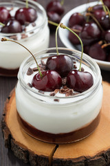 dessert with cream and jam in glass jar, vertical, closeup