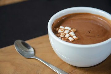 Hot cocoa with mini marshmallows on wooden board