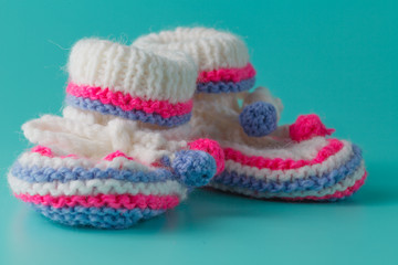 Fototapeta na wymiar Baby birthday invitation. Knitted booties closeup view