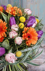 Bouquet of orange gerbera daisies, violet tulips and pink roses