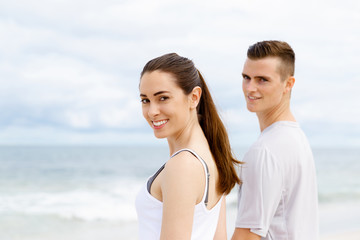 Fototapeta premium Young couple looking thoughtful while standing next to each other on beach