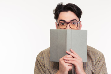 Young man covering his face with book