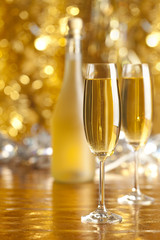 Happy new year - two glasses and bottle of champagne on golden s
