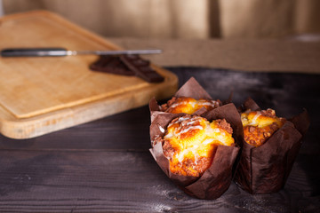 Muffins witch chocolate on wooden background. 