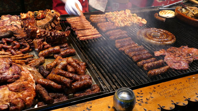 Romanian traditional sausages (mici), skewers and grill steaks on a traditional winter street fair. 4K footage.